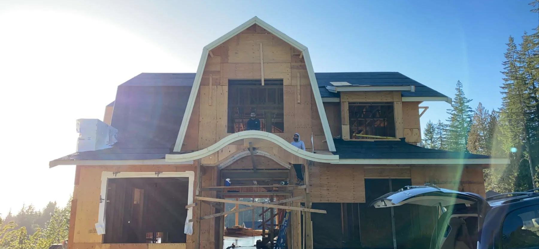 Custom home with curved architectural roof framing under construction